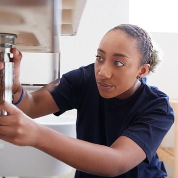 Woman fixing a sink at home